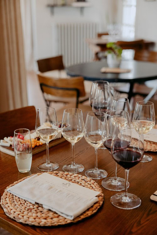 Wine tasting experience with glasses of white and red wine, set in a cozy, well-lit room.