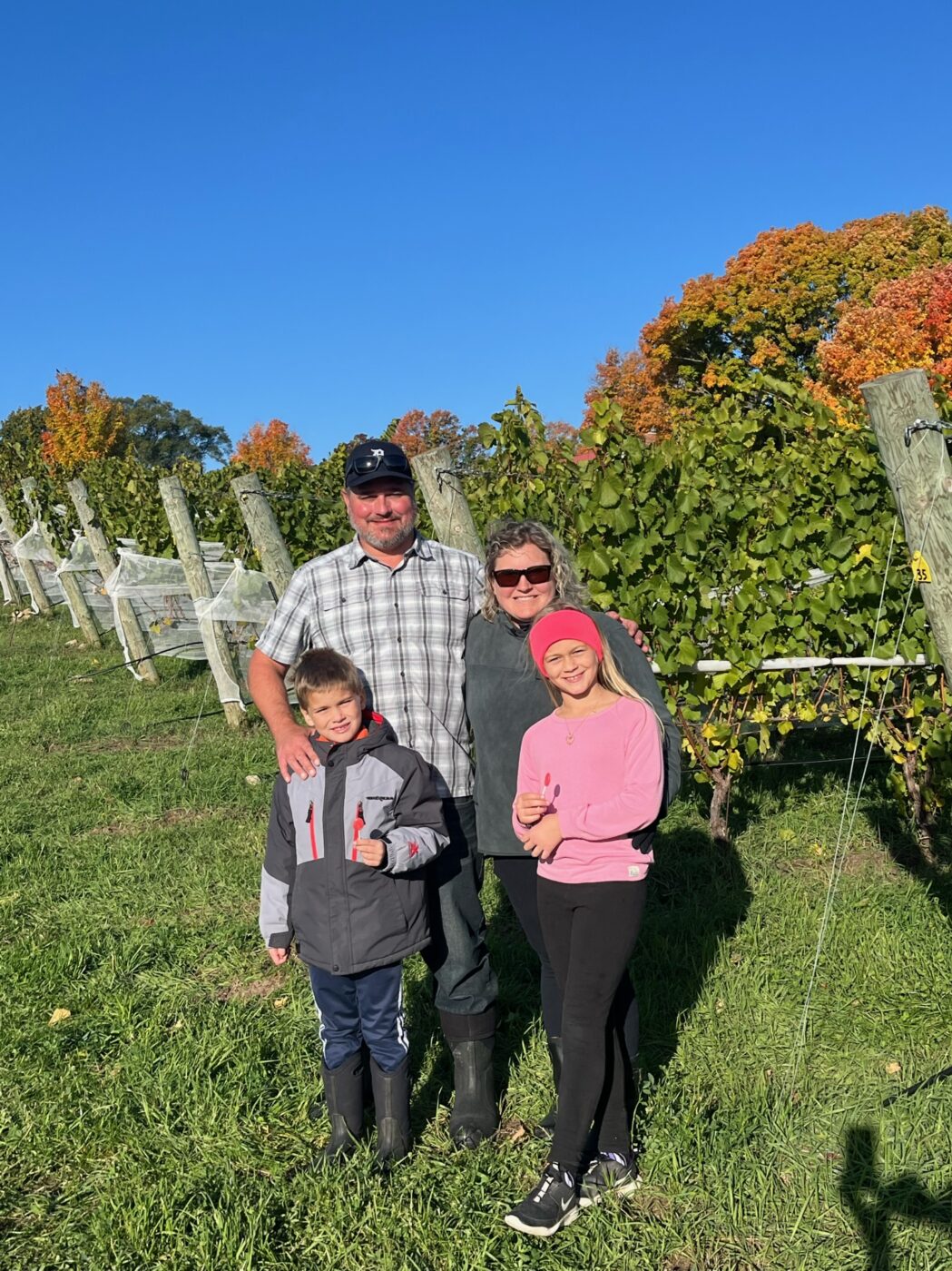 Beautiful family enjoying the 2022 BOS Wine harvest in a vineyard.