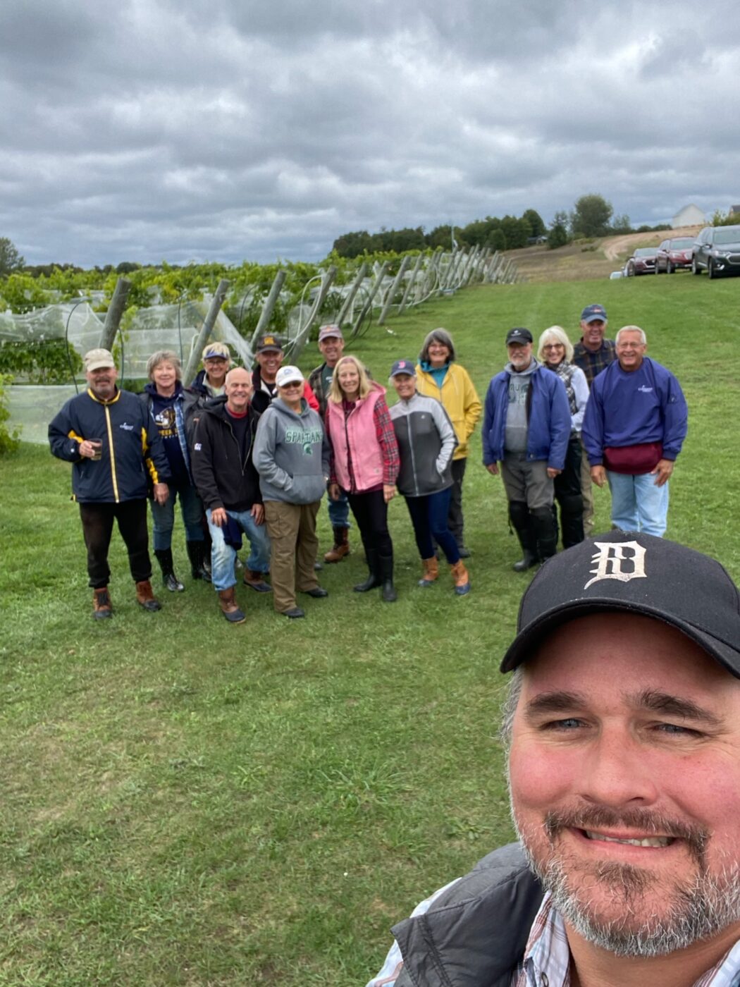 Group of people at Bos Wine vineyard during 2022 harvest, smiling and enjoying the outdoor experience.