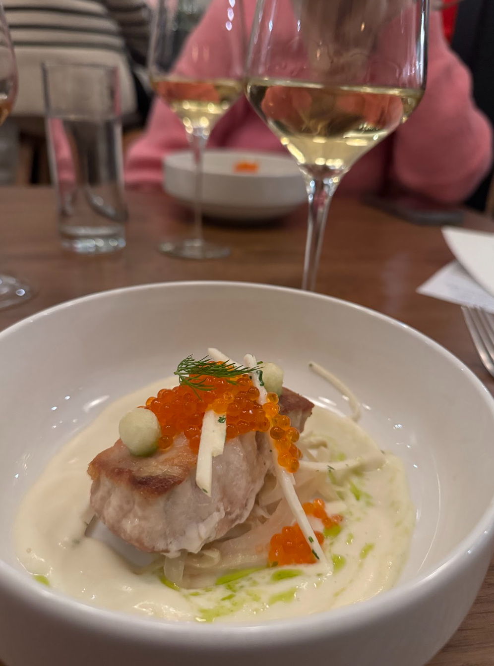 Elegant fish dish with caviar, garnishes, and creamy sauce served at Bos Wine restaurant.